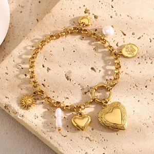 Detailed view of 18K gold plated charm bracelet with baroque pearls and heart charms