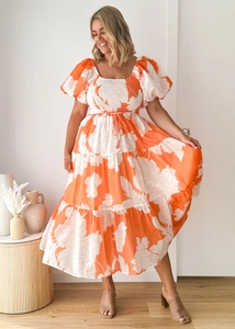 Detail of elegant orange and white floral print with puff sleeves and smocked bodice dress