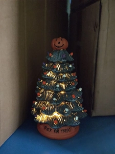 Detail of Halloween ceramic tree with glowing bulbs and Trick or Treat base