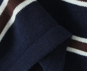 Detailed macro shot of blue and tan striped knit fabric texture on polo top