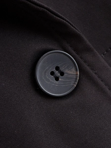 Macro detail of elegant black double-breasted coat buttons and textured fabric weave