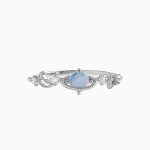 Macro detail of silver ring featuring light blue planet stone and zircon vine setting