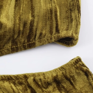 Dettaglio della trama del tessuto ciniglia verde oliva e cuciture fini sull'abito di velluto