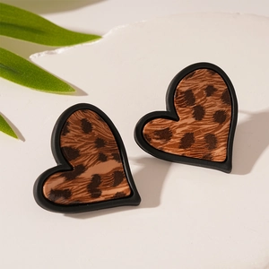 Détail des boucles d'oreilles en forme de cœur à motif léopard sur pierre blanche