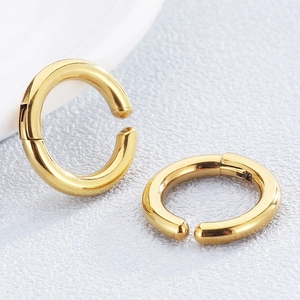 Macro view of gold stainless steel C-shaped ear cuffs with smooth polished metal finish
