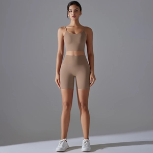 Dettaglio degli shorts sportivi a vita alta e del crop top coordinato in tessuto nude