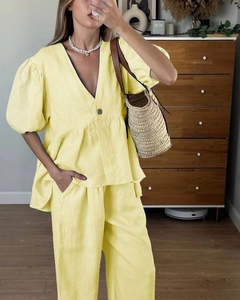 Close-up of yellow linen set featuring V-neck puff sleeve top and wide-leg trousers
