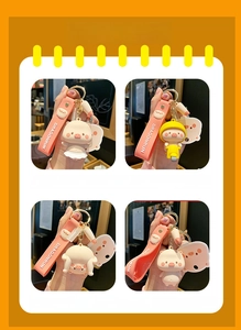 Detailed views of four cute pink cartoon pig keychains with silicone straps and gold hooks
