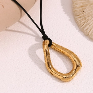 Detail of 18K gold-plated irregular teardrop pendant with textured finish on water drops