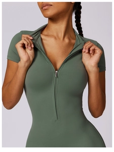 Close-up of olive green yoga bodysuit showing the half-zip collar and ribbed texture