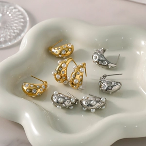 18k gold and silver chunky teardrop earrings with crystals and pearls in a ceramic dish