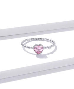 Macro detail of a 925 silver ring featuring a pink heart-cut gemstone and twisted band