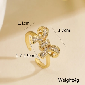 Detailed view of golden bow ring with cubic zirconia showing 1.1cm x 1.7cm dimensions