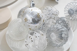 Close-up of white and silver Christmas ornaments with gold glitter in a ceramic plate