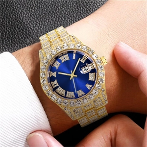 Luxury gold iced-out quartz watch with blue Roman dial and crystal-encrusted band on wrist