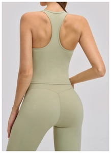 Detail view of racerback sports bra and high-waisted yoga leggings in sage green