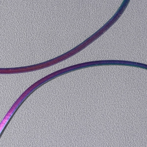 Macro shot of iridescent rainbow snake chain necklace with smooth gradient metallic finish