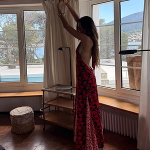 Detail showing the sexy backless design and halter neck of this red floral maxi dress