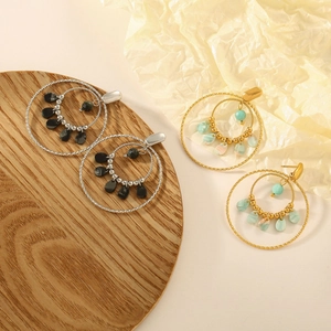 Detail of French resin drop earrings in gold and silver with colorful teardrop beads