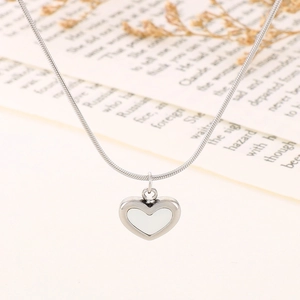 Close-up of heart pendant necklace with white enamel inlay on a delicate silver chain