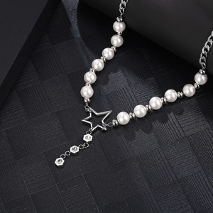Silver bead and pearl necklace featuring star pendant and crystal flower charms on dark surface