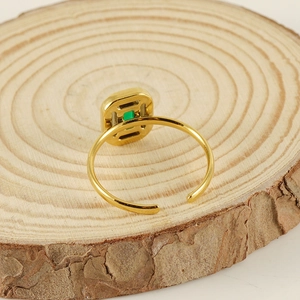 Detail view of adjustable gold-plated ring with a rectangular green zircon stone