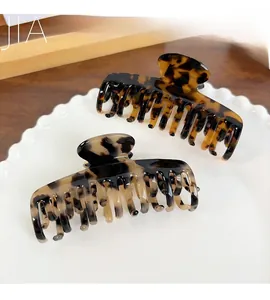 Detailed top view of tortoise shell acetate hair claws on a decorative ceramic plate