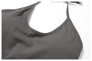 Macro detail of dark grey halter top showing high-stretch fabric and double-needle stitching