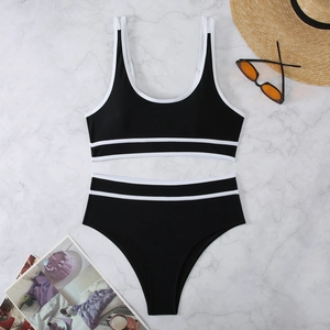 Two-piece black bikini with white trim and high-waisted bottoms on marble background