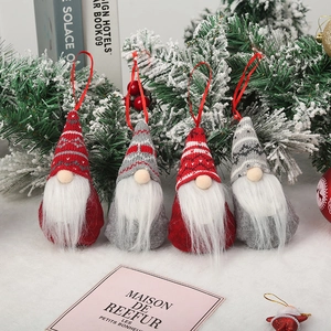 Set of four plush Christmas gnomes with knitted hats and white beards on snow background