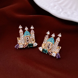 Detailed macro view of 18K gold plated castle earrings with colorful zircon on red silk