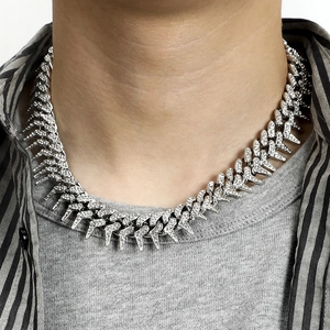 Close-up of silver iced-out Cuban chain necklace with spiked thorns on a model