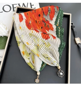 Close-up of pleated floral scarf necklace with magnetic clasp and pearl pendant detail