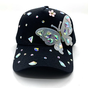 Detail of black baseball cap featuring 3D butterfly patch and colorful rhinestones