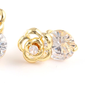 Vue macro de boucles d'oreilles rose évidée en or avec cristaux de zircon sur fond blanc
