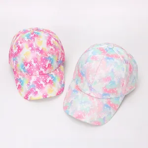 Nahaufnahme von Kinder-Baseballkappen mit Einhorn-Motiv und regenbogenfarbenem Verlaufsmuster