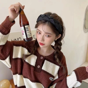 Chunky braided black headband for women styled with a striped knit sweater