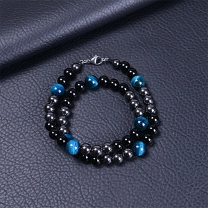 Détail du collier de perles en oeil de tigre bleu, agate noire et pierres magnétiques