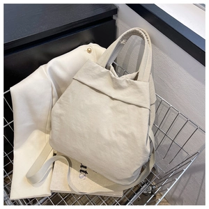Close-up of lightweight off-white nylon tote bag with soft pleated texture in a cart