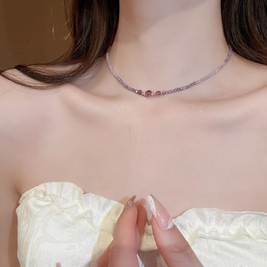 Detail showing amethyst beaded necklace with gold spacer beads worn by a model