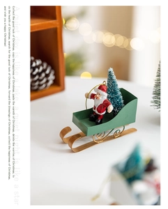 Detailed view of Santa Claus on green and gold metal sleigh with a mini Christmas tree