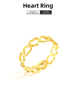 Detailed close-up of hollow heart-shaped titanium steel ring in polished golden finish
