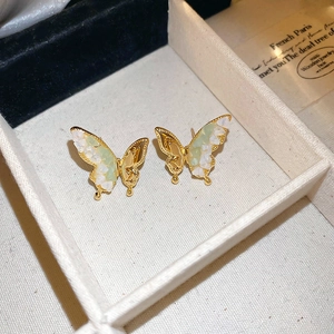 Vue détaillée de boucles d'oreilles papillon dorées avec incrustation de pierres