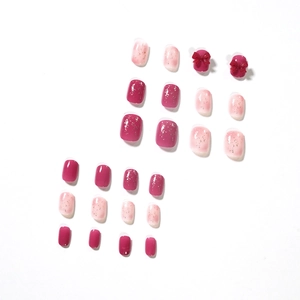 Unghie finte sfumate rosa con fiocchi 3D rossi e glitter su uno sfondo bianco pulito