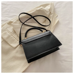 Gros plan détaillé d'un sac à main en cuir noir mat avec des détails en métal doré clair
