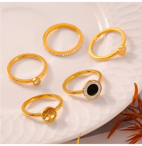Detailed set of five gold plated stainless steel rings with tree of life and heart charms