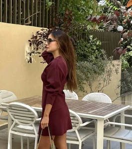Détail d'un ensemble en maille bordeaux avec haut à manches longues et jupe en extérieur