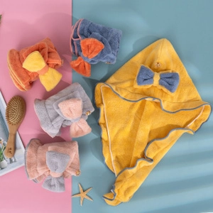 Detail of coral fleece hair drying wrap with decorative bow and button closure