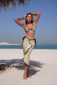 Detail of beige bikini top with black contrast trim and matching beach wrap skirt
