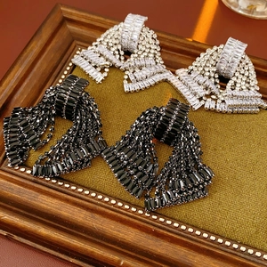Detailed view of silver and black bow-knot earrings with shimmering crystal rhinestones